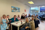 Alun Cairns visiting a table full of people from Age Connects