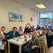 Alun Cairns visiting a table full of people from Age Connects